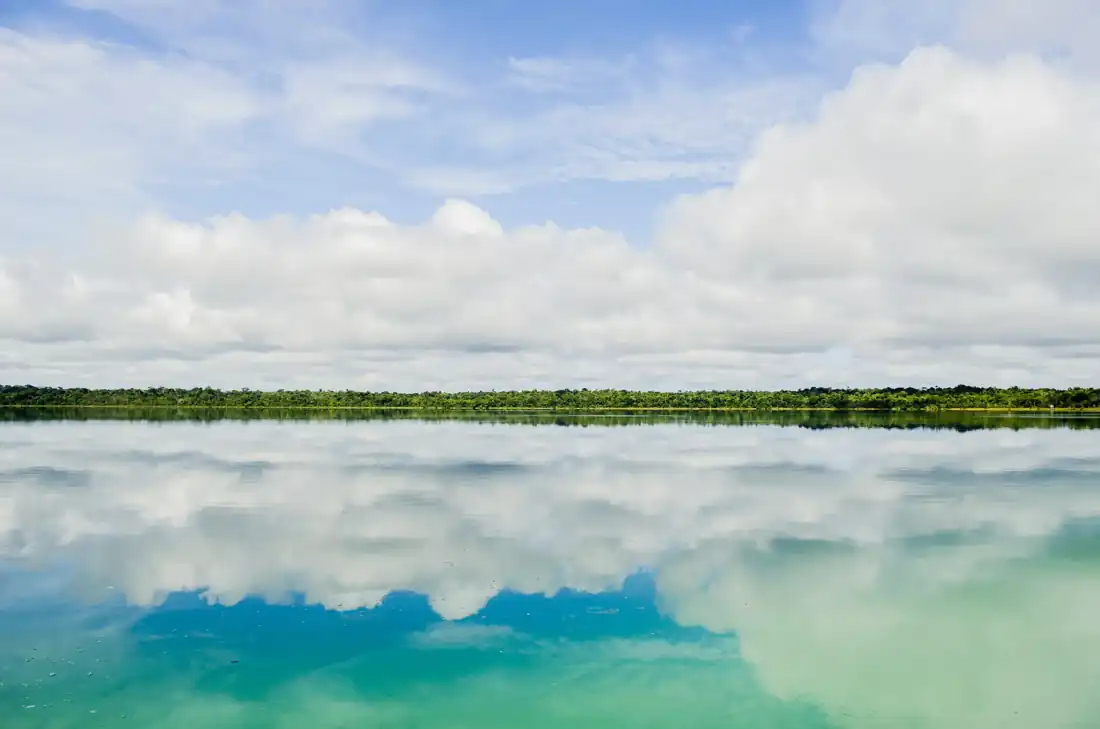 Lago de aguas claras bajo un cielo azul